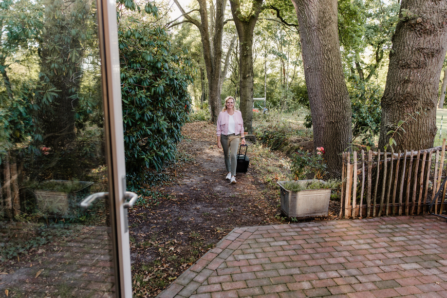 Wandelen over een bospad tussen hoge bomen bij camping De Poel in Opende